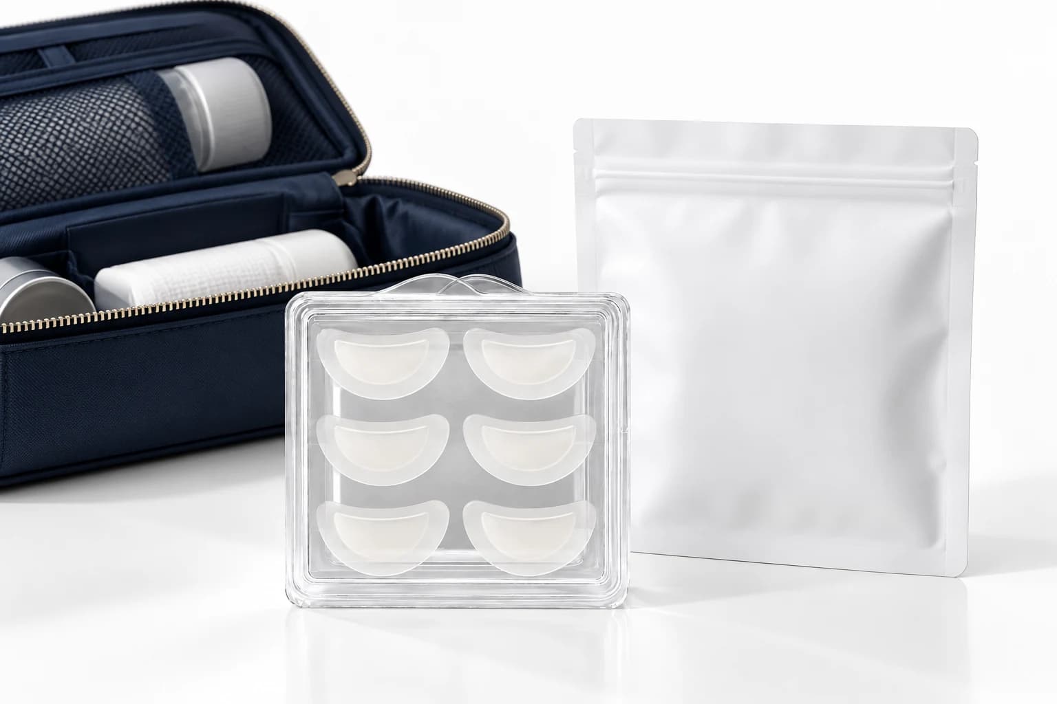 Curved patch tray, plain illustrative pouch, and navy travel organizer on white.