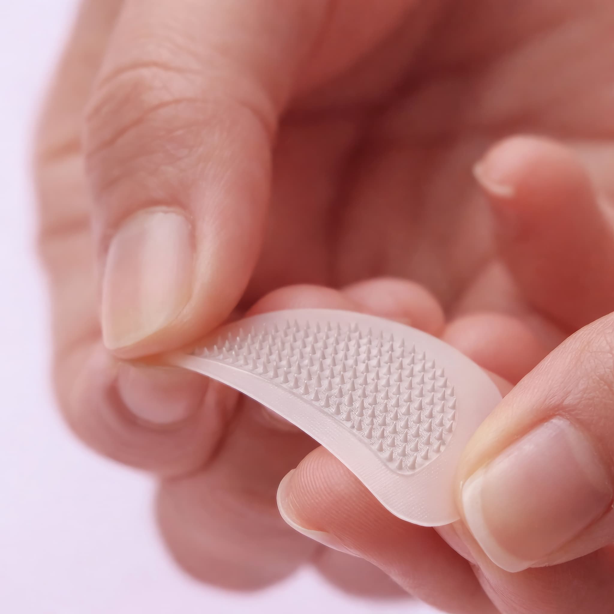 Hand-held CELLUL EYES patch showing the fine raised structures across its curved surface